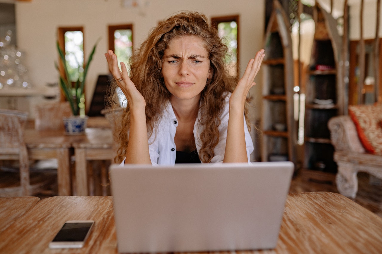 why performance management sucks - woman frustrated and looking at her computer with her hands in the air
